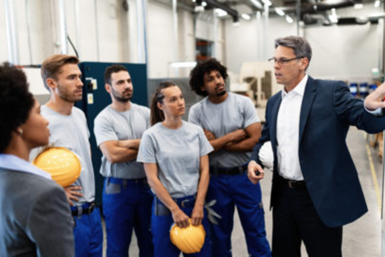 Manufacturing business leader speaking with employees