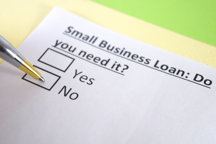 hand hovering over check mark asking: Small business loan: do you need it? Yes or No.