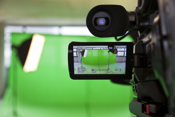 Camera filming a green screen studio