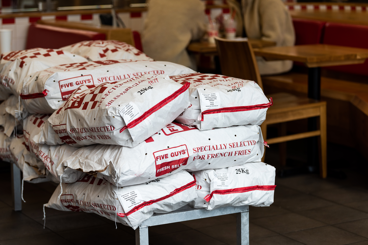 A stack of bags of potatoes at Five Guys.