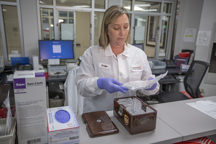 Laboratory technician prepares a sample to be shipped via drone