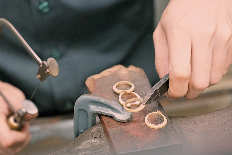 Manufacturer working by hand to shape small metal components