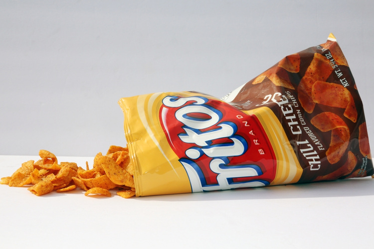 Bag of Frito's corn chips on its side with the contents spilling out.