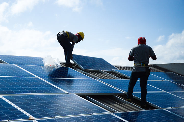 Two workers installing solar panels