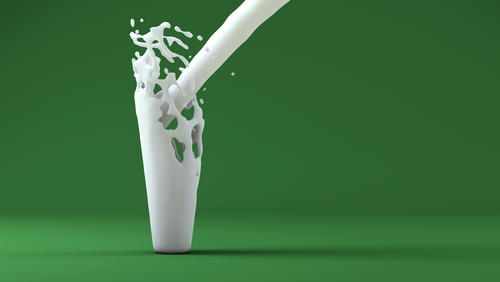 Milk splash in invisible glass on green background