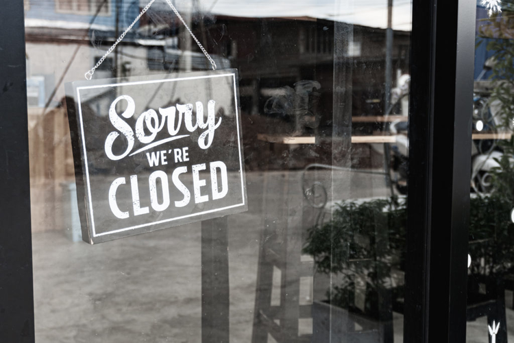 Closed sign in local store window. 