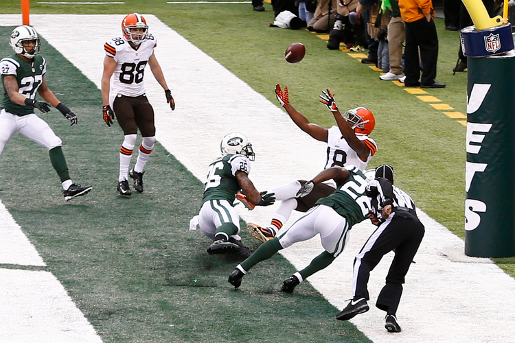 Cleveland Browns wide receiver Greg Little (18) leaps as New York Jets defensive back Aaron Berry (22) and safety Dawan Landry (26) defend during the first half at MetLife Stadium.