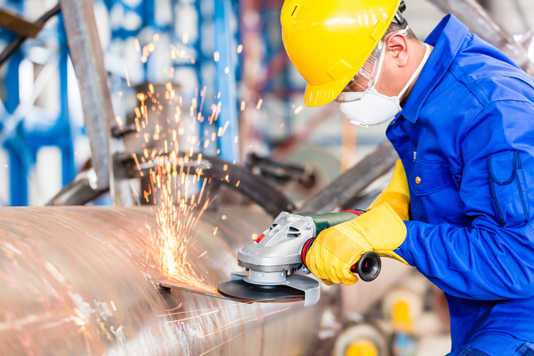 Employee in an Industrial Manufacturing Plant Working on a Pipeline.