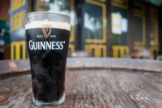 Picture of a Guinness on a wooden surface outside of a pub