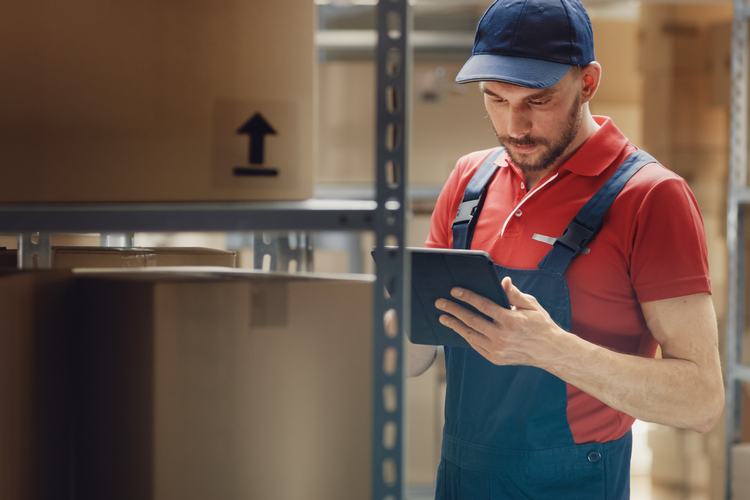 Warehouse Worker Uses Digital Tablet For Checking Stock