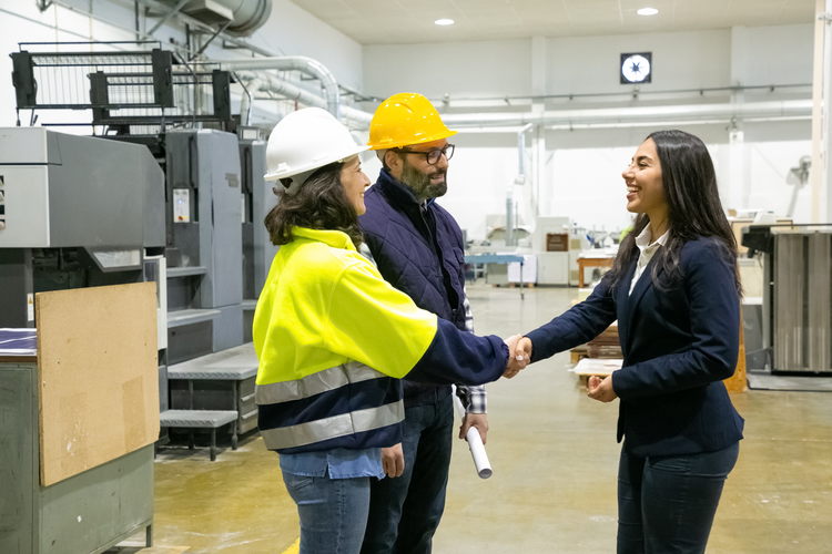 woman shaking hands with two industry professionals