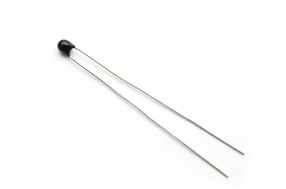A thermistor in an encapsulated package with leads extending from it.