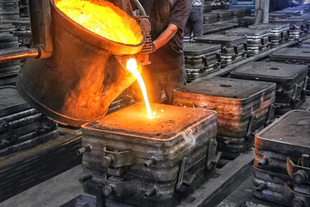 Molten metal being poured into molds in a foundry.