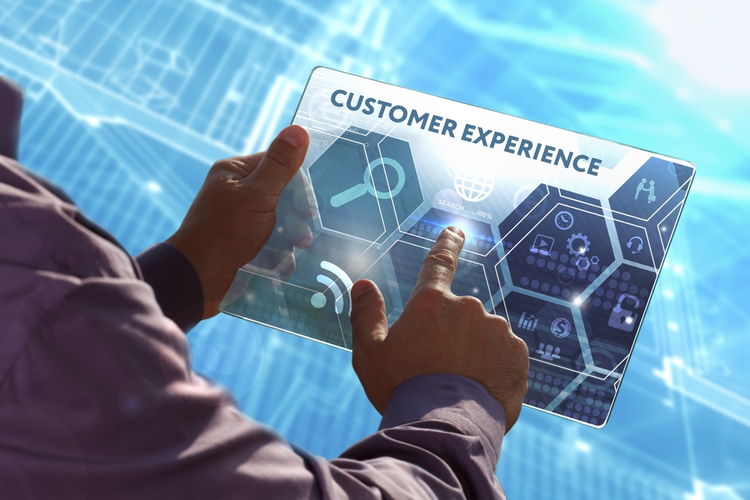 Businessman working on a tablet with customer experience graphic.