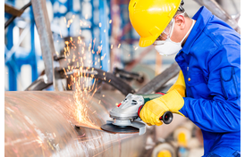 Employee in an Industrial Manufacturing Plant Working on a Pipeline.