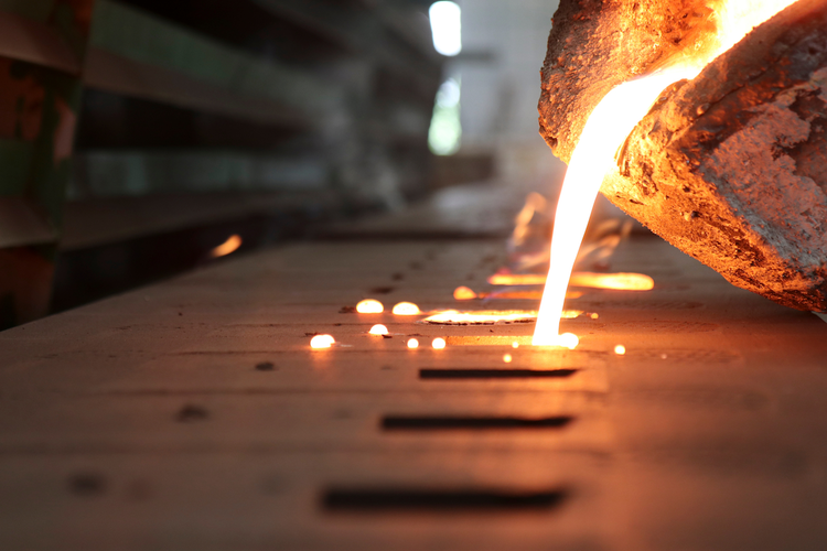 Molten iron being poured into mold during sand casting process