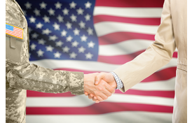 Soldier and civilian shaking hands in front of American flag to represent business Department of Defense and American manufacturers