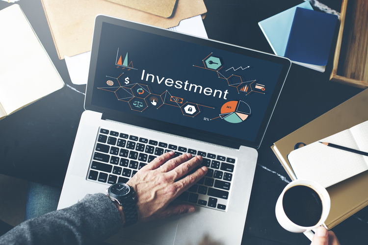 Man on laptop with Investment on screen