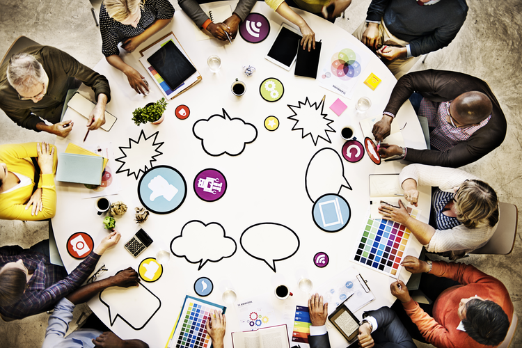 People around a table using different forms of communication