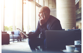 Man using laptop, tablet, and smartphone