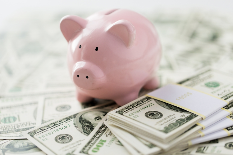 Piggy bank on top of $100 dollar bills.