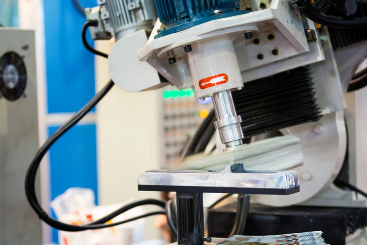 Robot arm finishing automotive part surface by lapping.