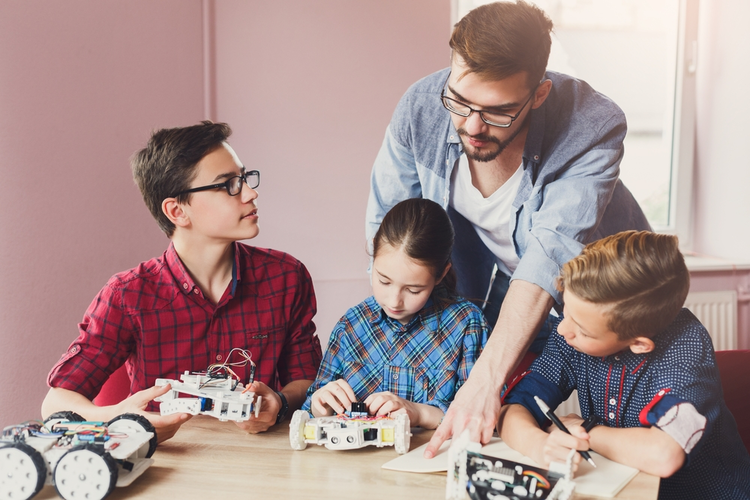 STEM education: Kids creating robots with teacher.