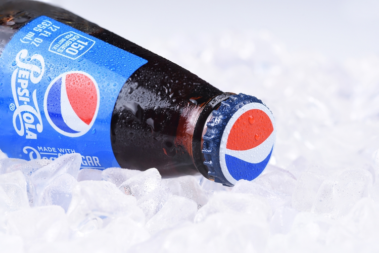 Soda bottle showing label on ice with condensation.