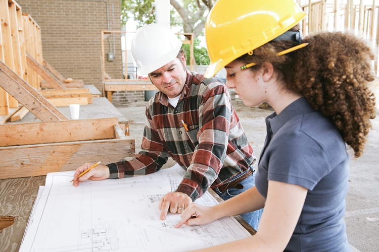 Trade school student learning to read construction blueprints.