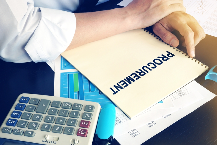 Businessman holding a book titled 'Procurement'.