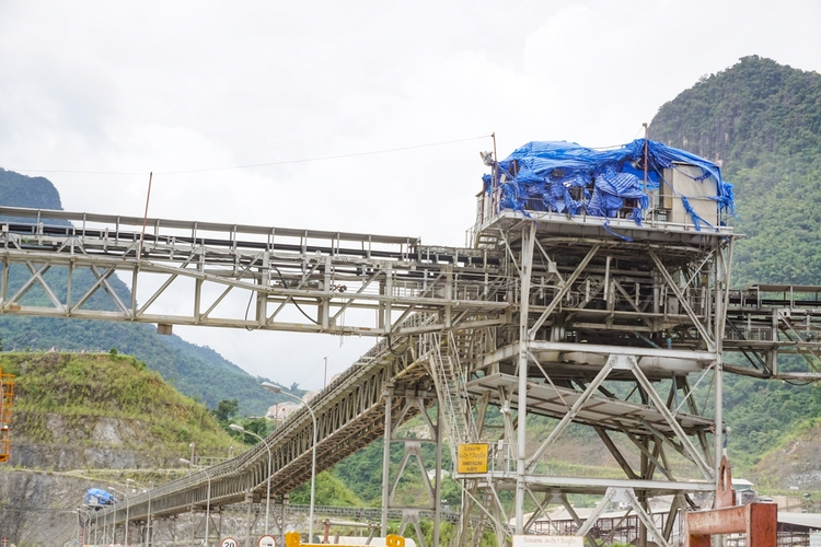 Overhead conveyor belt for concrete transportation on a construction site.