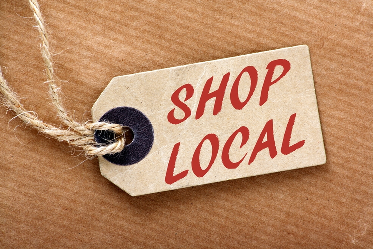 The words 'Shop Local' in red text on a brown paper price label.